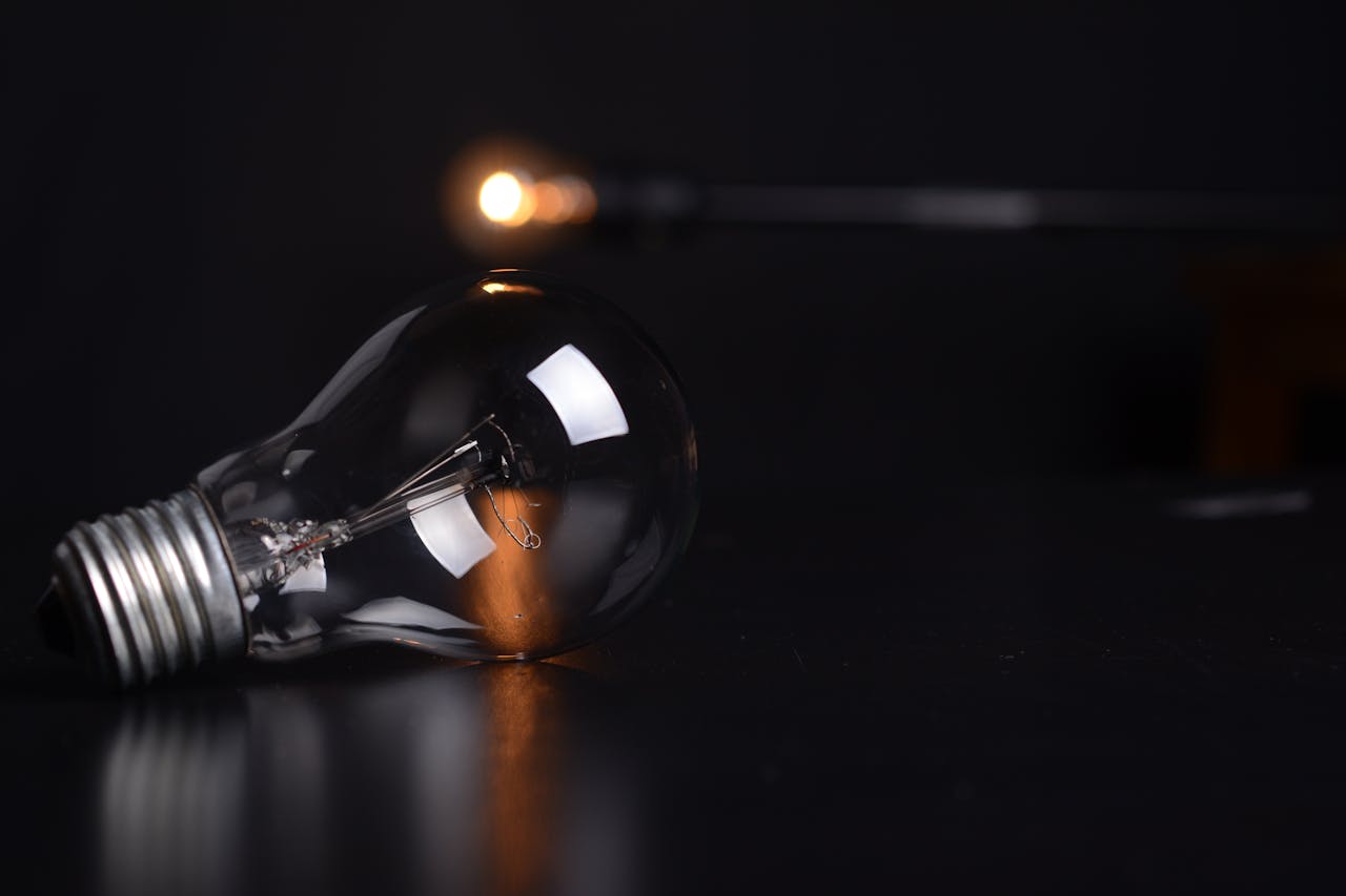 Detailed shot of a reflective light bulb on a dark background, showcasing lighting and reflections.